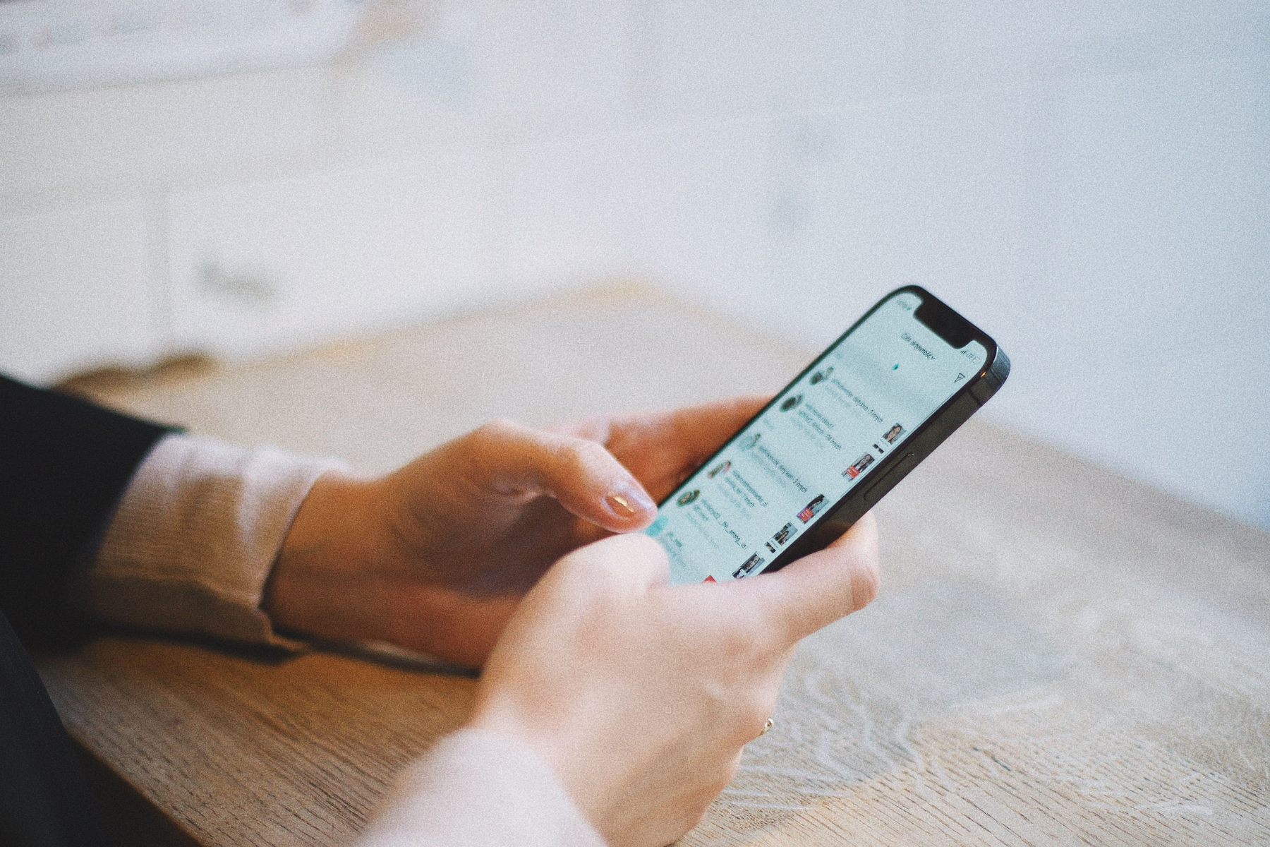 Hands holding a phone while scrolling
