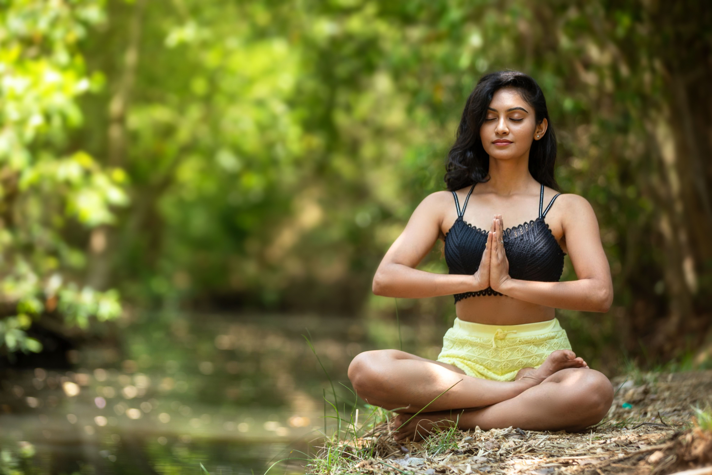 Young Indian woman sitting peacefully outdoors in a forest